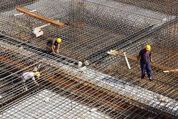 worker in the construction site making reinforcement metal framework for concrete pouring