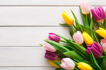 Bright tulips bouquet on white wood background, copy space