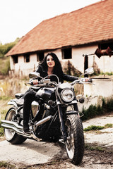 Beautiful brunette woman with a classic motorcycle (cinema bleach bypass effect)