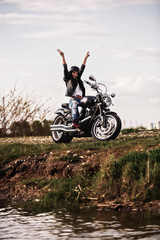 Beautiful brunette woman with a classic motorcycle (cinema bleach bypass effect)