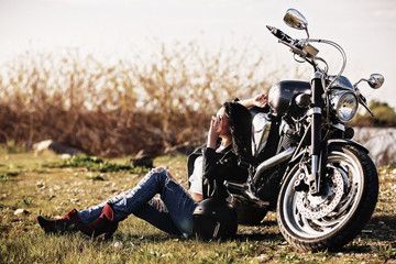 Beautiful brunette woman with a classic motorcycle (cinema bleach bypass effect)