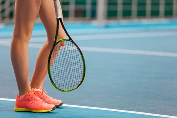 Fototapeten Legs of young girl in a closed tennis court with racket © master1305