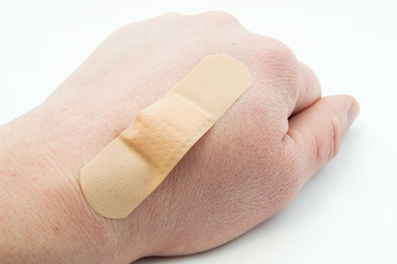 Wounded back of the wrist (cut, burn) and the wound is covered with plaster or band-aid. Use of first aid kit contents in patients with lesions of the skin or the primary wound treatment at the doctor