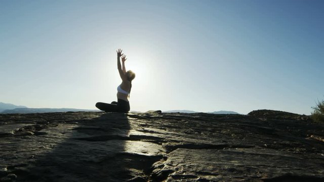 panning shot of woman doing yoga in the desert