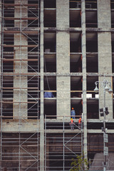 building high-rise buildings, workers work on the scaffolding