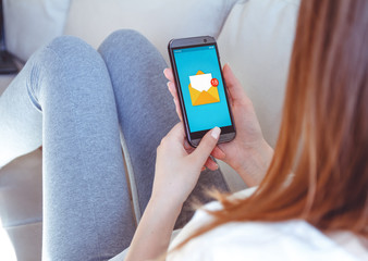 Girl lies on a sofa with a phone in his hand.