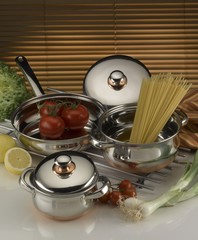 pots and pan on a kitchen counter with some pasta and vegetables