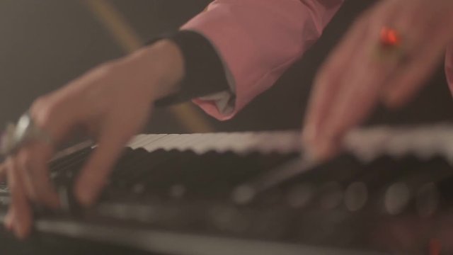 Hands of musician playing keyboard at concert