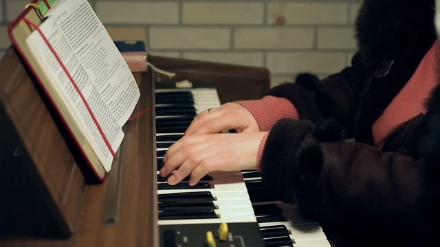 Adult woman's hands playing an old antique organ.