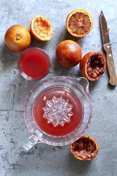 Making blood orange juice with a hand citrus squeezer
