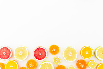 Tropical summer mix with fresh citrus fruits - lemon, orange, mandarin, grapefruit and sweetie on white background. Flat lay, top view.