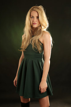 Eine Frau mit wildem blondem Haar im Minikleid in grün