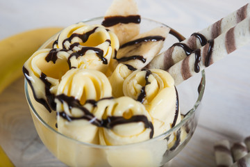 Roll of banana ice cream. Fresh fried fruit ice cream, ice roll on a light wooden background