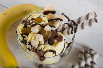 Roll of banana ice cream. Fresh fried fruit ice cream, ice roll on a light wooden background