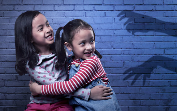 Scared Two Asian Little Girl Looking At Black Ghost Hand