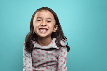 Smiling asian little girl and her broken teeth