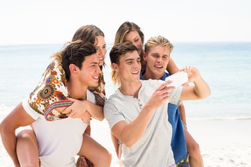Friends looking in mobile phone at beach