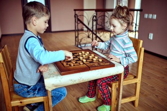 Children playing draughts or checkers board game