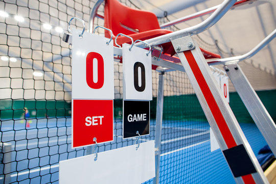 Umpire chair with scoreboard on a tennis court before the game.