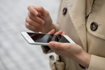 携帯電話を使うビジネスウーマン、メール、インターネット、検索、コート