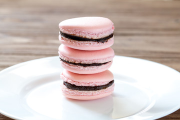 Pile of three french desert pink macaron cakes on white plate