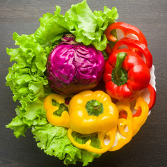 Clean washed fresh vegetables lie in a salad bowl, lettuce, red cabbage, red and yellow pepper