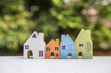 Close-up miniature house over blurred nature bokeh background, outdoor day light