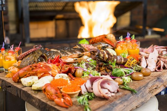 Fresh seafood and meat platter on wooden table