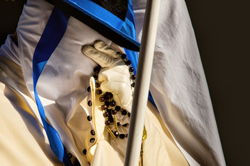 TARANTO, ITALY - APRIL 13-14, 2017: On Holy week members of the fraternities in white robes, covering their faces with hoods, follow an ancient route carrying the statues of the Stations of the Cross