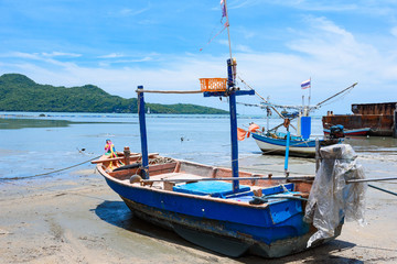 Fototapeta premium Fishing boats aground on the beach over cloudy sky at Prachuap Khiri Khan, Thailand.