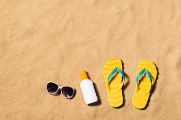 Fototapeta na wymiar Summer vacation composition. Flip flops, sunglasses and sunscree