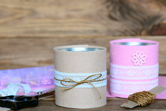 Recycled tin cans for storage. Easy and cheap idea for beautiful decorating old things. Recycled craft concept. Wooden background