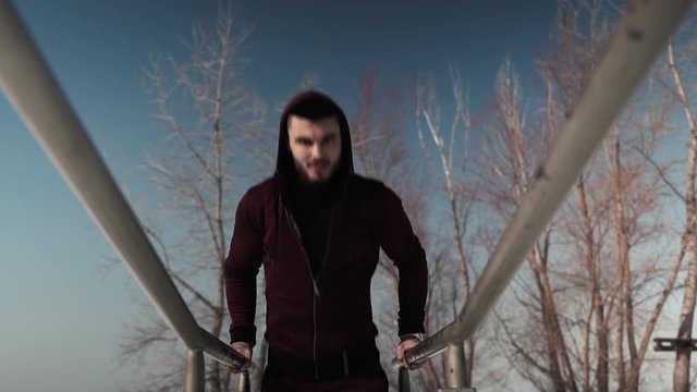 Young caucasian or middle eastern man exercising on parallel bars