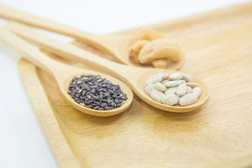 sunflower kernels and black sesame and cashew nuts on spoon