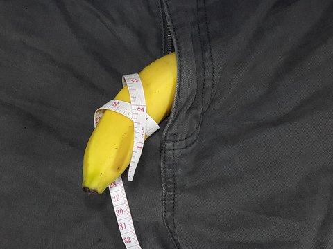 Banana and measurement tape on a pant. Medical and men's health concept