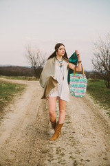 Hipster girl standing on a dirt road.