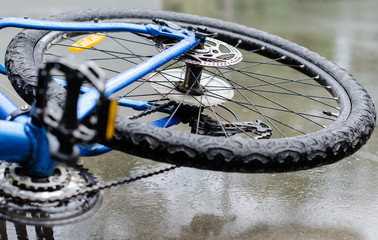 Bicycle lying on wet concrete after accident