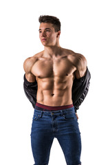 Obraz premium Handsome young muscular man shirtless wearing jeans, taking off leather jacket on naked muscle torso, isolated on white background in studio shot