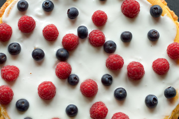 blueberries and raspberries as decoration of cheese cake, top view