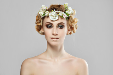 Fashion beauty model girl with flowers in her hair. Perfect creative make up and floral art hairstyle.