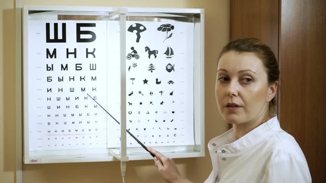 Young blond-haired woman examining her eyesight at the optometrist's. HD