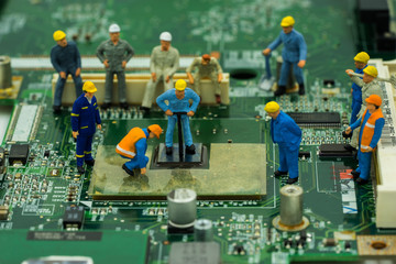 abstract mini worker team try to repair cpu on mainboard - can use to display or montage on product