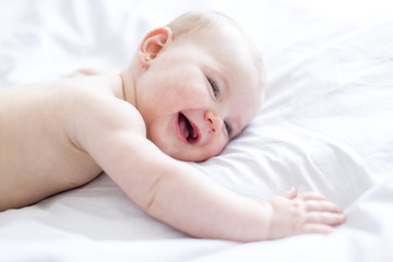 Baby girl in white bedding at home look nice