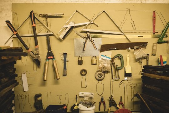 Tools hanging on wall at beekeeping factory