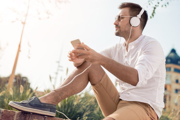 Happy young man listening to music on a smart phone