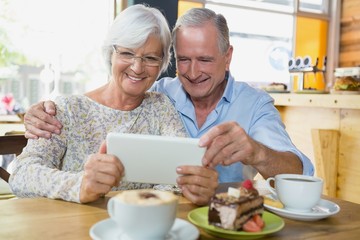 Fototapeta na wymiar Happy senior couple using digital tablet