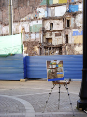The easel on the background of destroyed building.