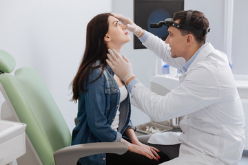 Positive otorhinolaryngologist checking nose of his patient