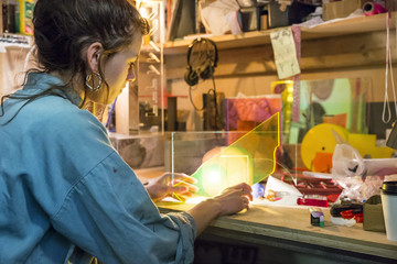Young woman looking at materials in a craft workshop