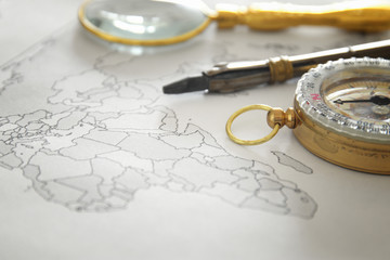 Image of map, magnifying glass and old compass. selective focus